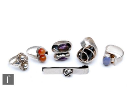 Five assorted mid 20th Century dress rings of varying form to include a hallmarked silver example set with two polished peach