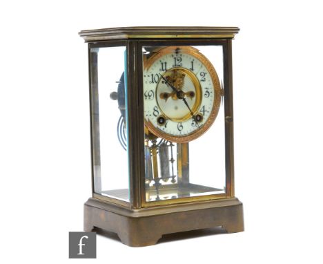 An early 20th Century brass cased Ansonia mantle clock, the dial, gong and mercury filled pendulum enclosed by bevelled glass