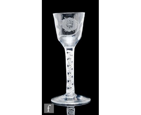 An 18th Century Jacobite drinking glass circa 1765, the ogee bowl engraved with a rose and bud on leafy bough with open winge