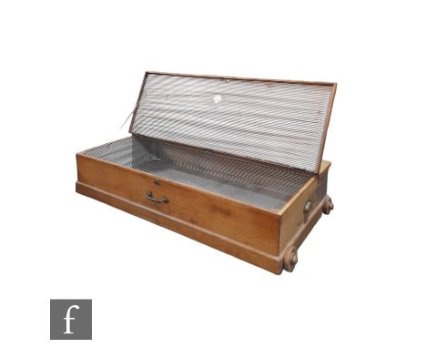 A stripped pine portable Stowaway trunk with part lift top, on wooden wheels, height 26cm x depth 62cm x width 122cm. 