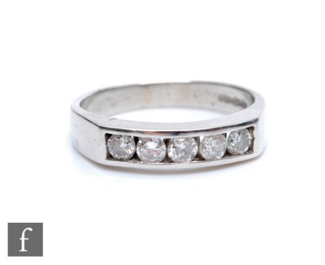 A platinum hallmarked diamond five stone ring, channel set brilliant cut stones to a plain shank, weight 5.5g, ring size M. 