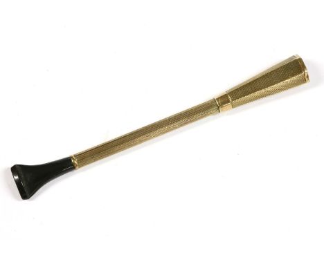 A Dunhill 9ct gold engine turned decorated cigarette holder, with a fluted column and a black mount piece signed Dunhill, Bir