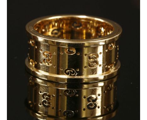 An 18ct gold Gucci 'Icon' ring,with pierced Gucci logo to the centre, with raised guards.  Signed 'Gucci'.  Swiss assay mark 