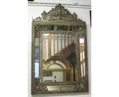 WALL MIRROR, 17th century style Dutch silvered metal with repoussé cast cushion frame, bevelled centre plate and angled margi