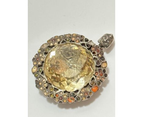 A late 19thc early 20thc brooch converted to pendant with faceted glass centre panel enclosed within a jewelled enamel floral