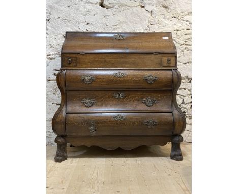 A late 18th century oak Dutch bombe bureau, fall front revealing interior fitted in typical fashion, over two trinket drawers