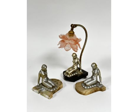 A pair of Art Deco silvered coated kneeling female figure bookends, mounted on alabaster bases and a matching lamp with scrol