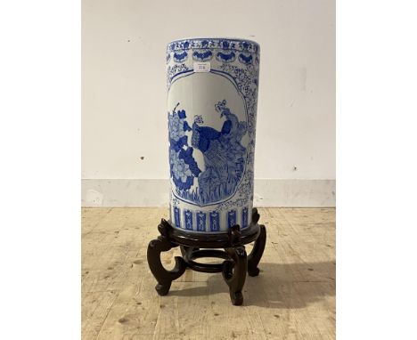 A modern Chinese style blue and white ceramic cylindrical stick stand, on carved hardwood base, H62cm,