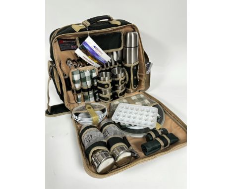 A Concept travelling picnic set in unused condition, complete with stainless steel flask, cups and flatware, plates, napkins,