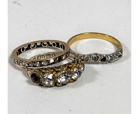 A 9ct gold paste set five stone graduated ring, a yellow metal clear stone set eternity style ring missing three stones, a ye