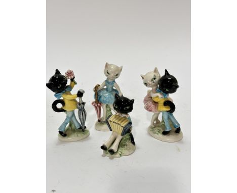 A Hummel collection of four various novelty cat figures including a courting couple, a female cat with umbrella and male cat 
