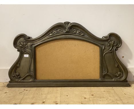 An Art Nouveau period patinated cast metal over mantel mirror frame, the scrolling frame typically decorated with floral tend