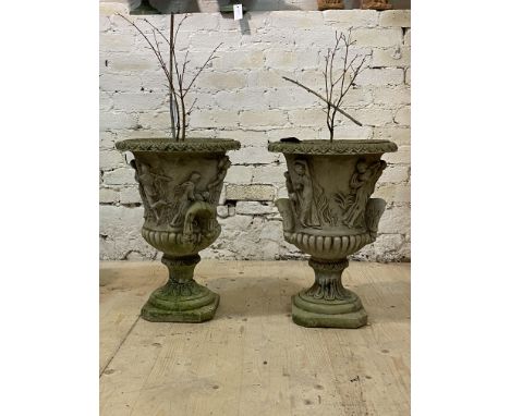 A pair of reconstituted stone garden urn planters, flared rim over twin handled body with Romo-Grecian imagery, on socle and 