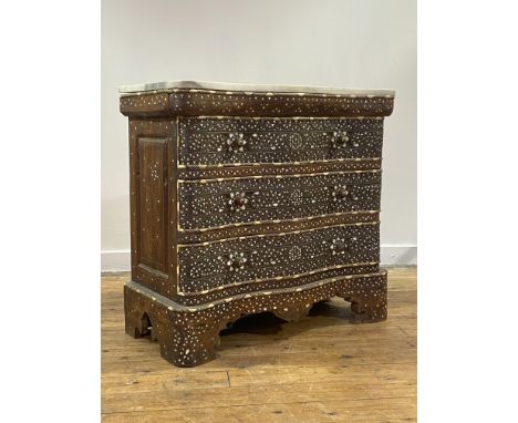 An Syrian hardwood commode of serpentine outline, the white&nbsp;variegated&nbsp; marble top over three drawers, panelled sid