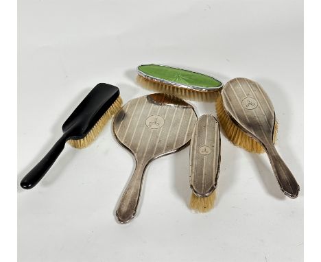 A Birmingham silver engine turned decorated three piece dressing table brush set with engraved initial A, and an ebony hair b