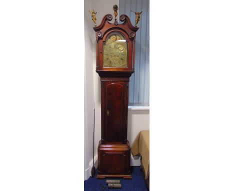 An early 19th century mahogany longcase clock with swan neck pediment carved figural terminals with hinged door on rectangula