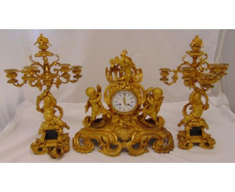 A French 19th century ormolu clock set with candelabra garnitures, the clock supported by putti, the white enamel dial with R