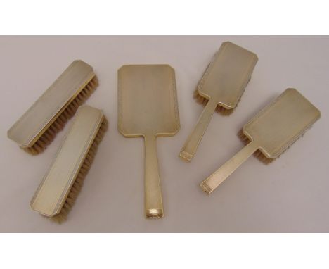 A hallmarked silver engine turned dressing table set, to include a hand mirror, two hair brushes and two clothes brushes (5)