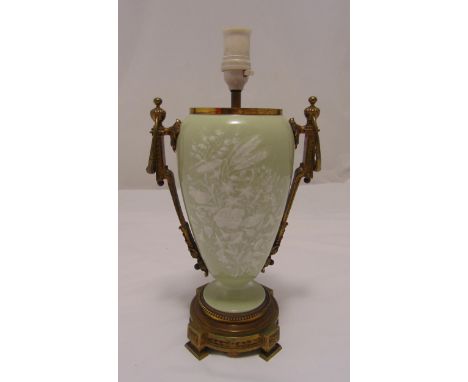 A Pate-sur-pate ovoid lamp base decorated with flowers and leaves against a sage green ground with gilt metal mounts and rais