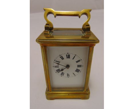 A French brass carriage clock of customary form, the white enamel dial with Roman numerals surmounted by a swing handle 11cm 