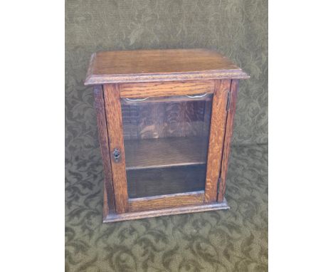 Early 20th oak smokers cabinet with pipe rack, 2 internal doors and bevel glass door, standing 34cm tall.