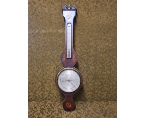 Early 19th century mahogany wheel barometer with silvered dial F. Faverio.  Broken arch pediment and boxwood shell and rosett