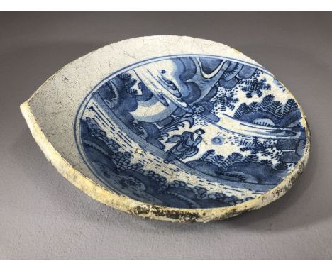 Sectional piece of a ceramic bowl, possibly Chinese with blue and white design of a figure in a landscape within blue concent