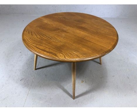 Blond Ercol circular coffee table on four turned legs with blue Ercol badge, approx 74cm in diameter and 45cm tall