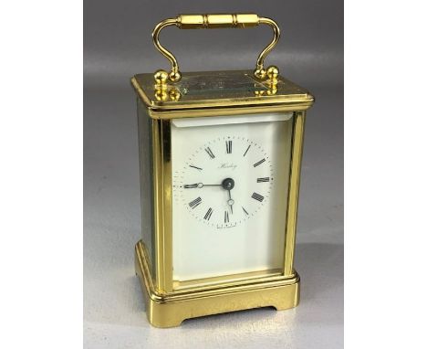 Carriage clock by Henley, white enamel dial with Roman numerals and makers name, the brass five glass case with swing handle,