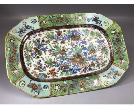 Small ceramic plate of oblong form with floral and foliate hand painted decoration on green ground, approx 28cm x 19cm 