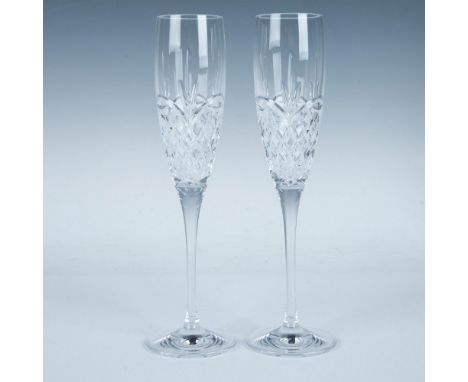 A pair of tulip-shaped, hand-cut and polished champagne toasting flutes adorned with a crisscross and feather motif. This ite