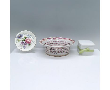 A delightful set of porcelain pieces, a small white plate with painted flowers, a white box tied with a green ribbon holding 