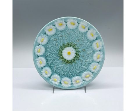 A small 7.25-inch round light blue plate decorated with daisies on the boarder and center. SMF Schramberg backstamp. Issued: 