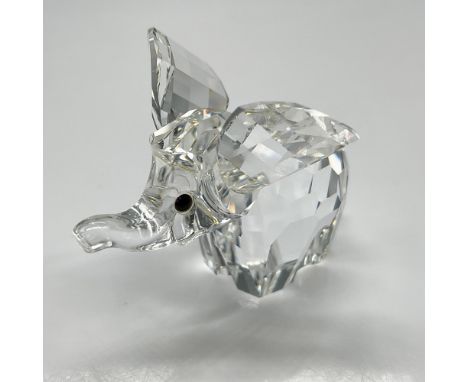 Clear, faceted crystal figural with widespread ears, trunk up and jet crystal button eyes. Swarovski backstamp. 7640 040 000.
