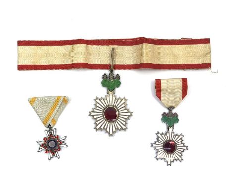 Three WWII Japanese medals, all in their lacquer presentation boxes (some with damage, and two with missing clasps) comprisin