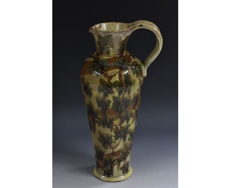 A Della Robbia ewer, designed by Annie Smith,  decorated with leaves and foliage, in mottled green and brown, 29cm high, AS m