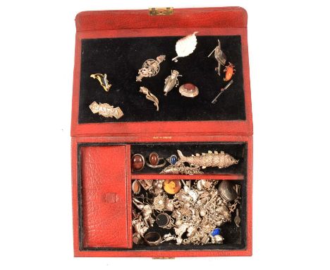 A red leather jewellery box with vintage silver jewellery, a silver charm bracelet full of silver charms and further loose ch