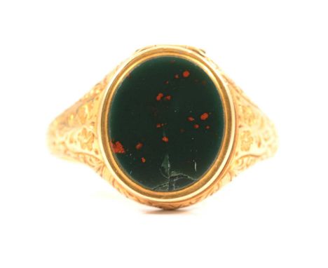 An 18 carat gold signet ring with oval head having a hinged compartment set with bloodstone, finely engraved shoulders and su