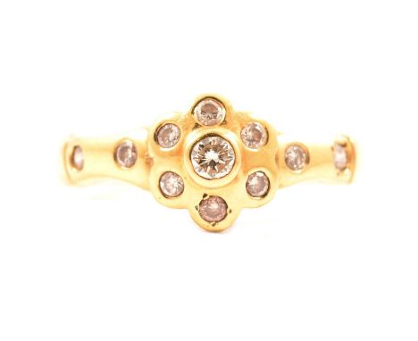 A diamond dress ring, seven brilliant cut stones pave set in an all yellow metal floral design head, 8.5mm diameter, two furt