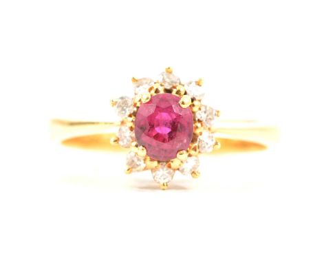 A ruby and diamond cluster ring, the oval mixed cut ruby 5.4x4.6, four claw set and surrounded by ten brilliant cut diamonds 