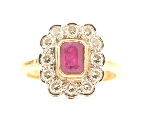 A ruby and diamond cluster ring, the emerald cut ruby 5.2x4.5mm collet set and surrounded by twelve brilliant cut diamonds, p