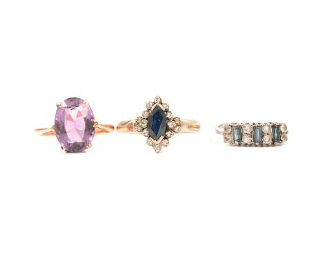 Three dress rings, an oval mixed cut amethyst 12.5x9.5mm, claw set in a rose metal mount marked 9c, ring size K; a marquise s