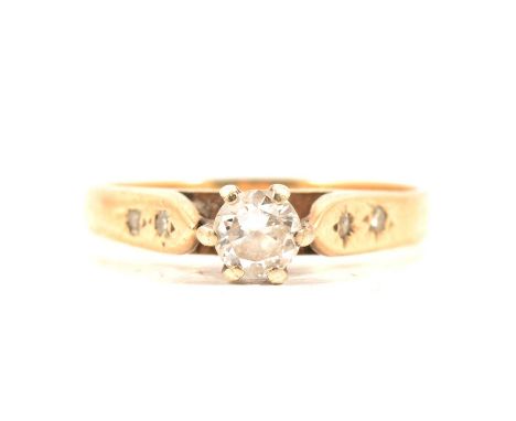 A diamond solitaire ring, the brilliant cut stone claw set in a yellow and white gold mount ring size H, two small diamonds s