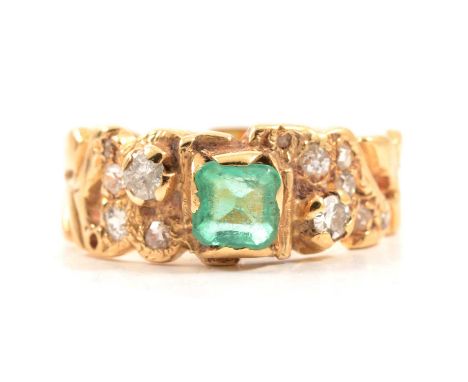 A contemporary emerald and diamond ring, the 5mm square cut emerald claw set in an all yellow metal mount with eleven old and