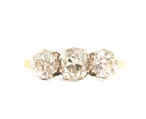 A diamond three stone ring, the old brilliant cut stones claw set in a yellow and white metal traditional three stone mount r