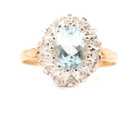A heat treated blue topaz and diamond cluster ring, the oval mixed cut topaz 9x7mm, claw set and surrounded by fourteen 8 cut