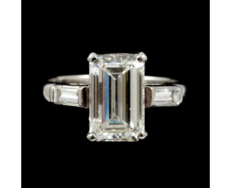 A diamond solitaire ring, the emerald cut stone four claw set in an all platinum mount, 2.6mm wide shank, Birmingham 2003, a 