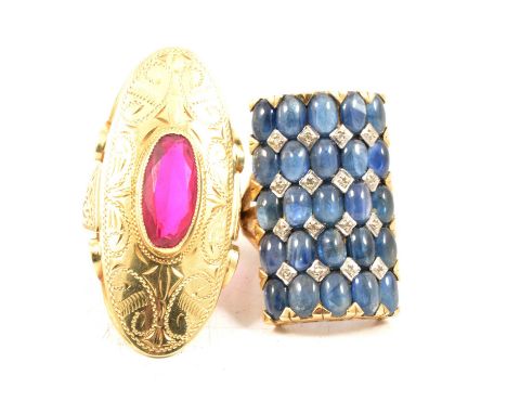 Two large gemset dress rings, one with a large oval faceted synthetic pink stone in a yellow metal mount with wide engraved s