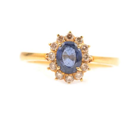 A sapphire and diamond cluster ring, the oval mixed cut sapphire, 6x4.8mm, surrounded by twelve brilliant cut diamonds claw s