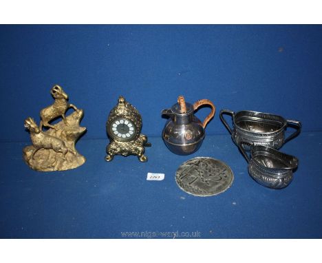 A small brass Carriage clock by Splendex, brass rams and three white metal jugs.